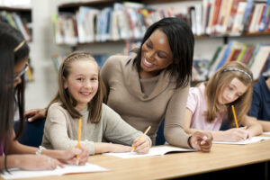 Black teacher smiles at white student