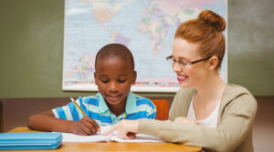 White teacher helping young Black student