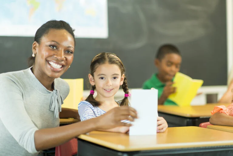 a Black elementary teacher and a young girl in a warm, welcoming classroom environment, with a focus on effective classroom management