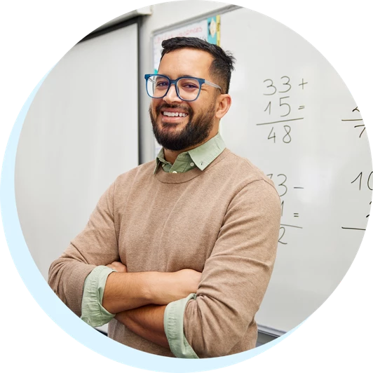 Teacher standing in front of a dry erase board with pride