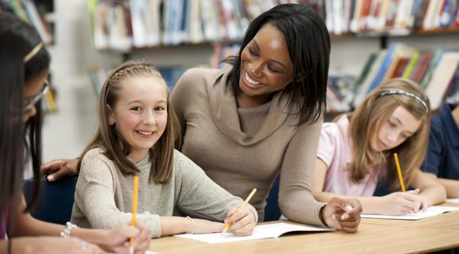 Black teacher smiles at white student