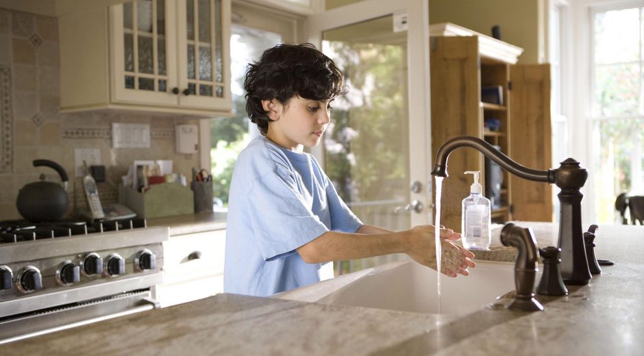 Young Boy washing hands to prevent coronavirus