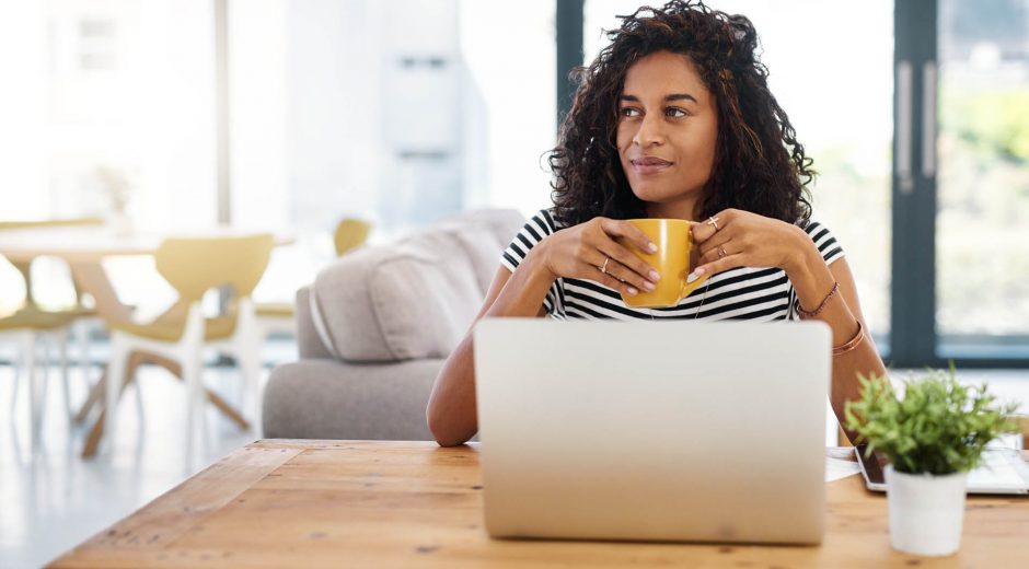 Cropped shot of an attractive young businesswoman sitting and looking contemplative while holding a cup of coffee in her home