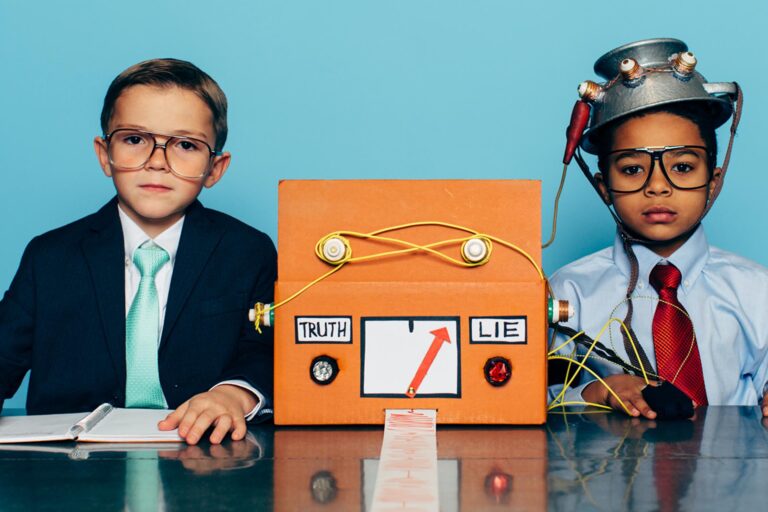 Two young boys and businessmen dressed in suits and glasses sit at a desk with a homemade lie detector machine. This serious interview is conducted in an office and the machine is predicting a lie from the job candidate. Dishonesty will eventually catch up to you.